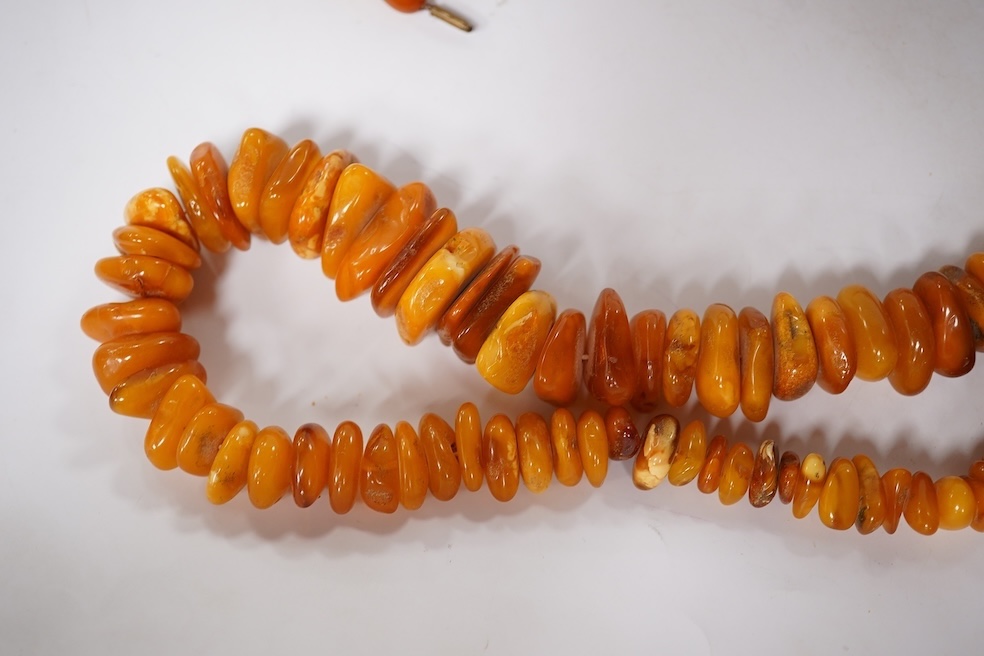 Three assorted amber necklaces including a single strand graduated oval bead necklace, 40cm, gross weight 37 grams, the other two necklaces gross weight 240 grams. Condition - poor to fair